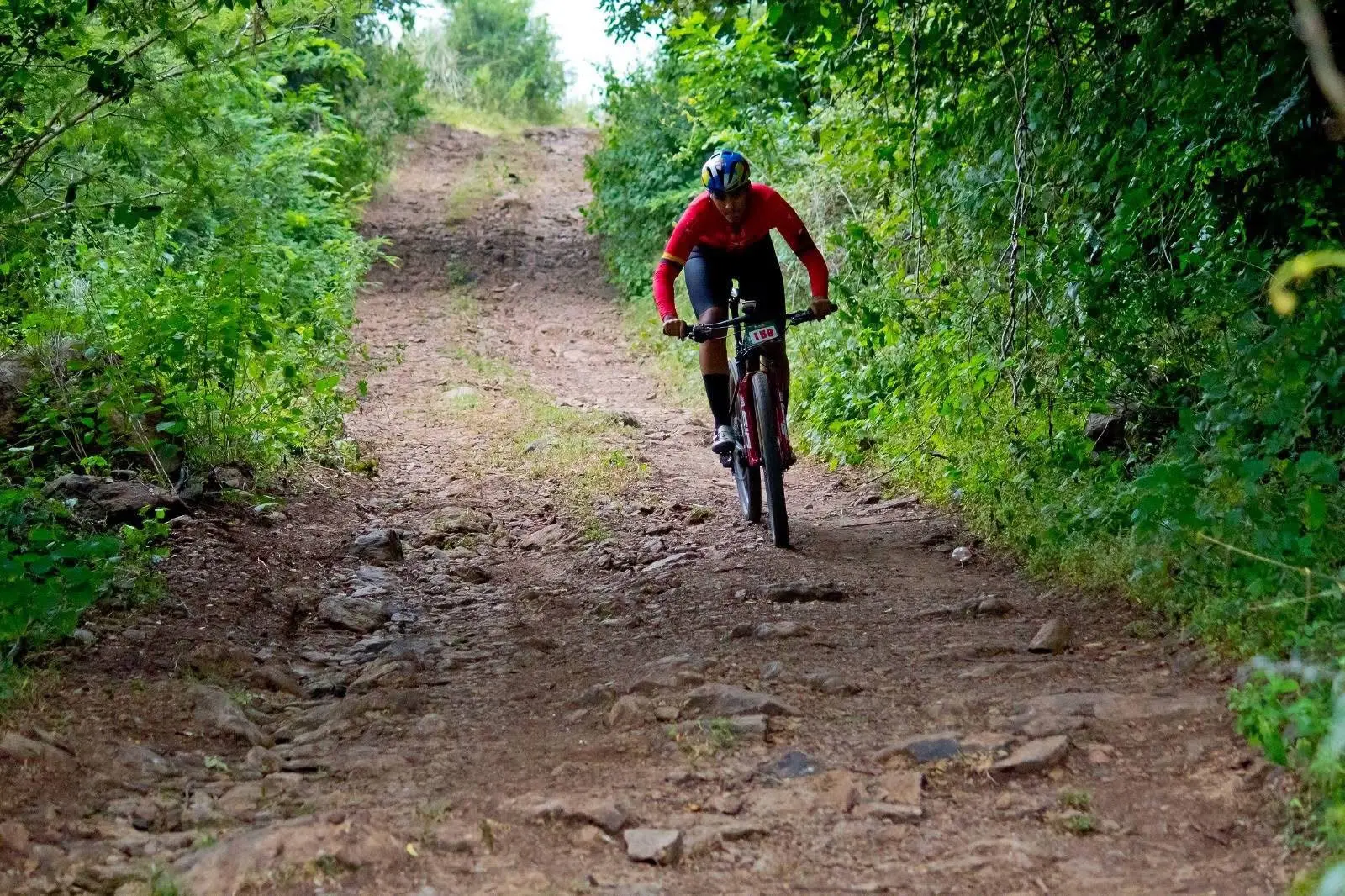 Ciclista de montaña subiendo un sendero rocoso
